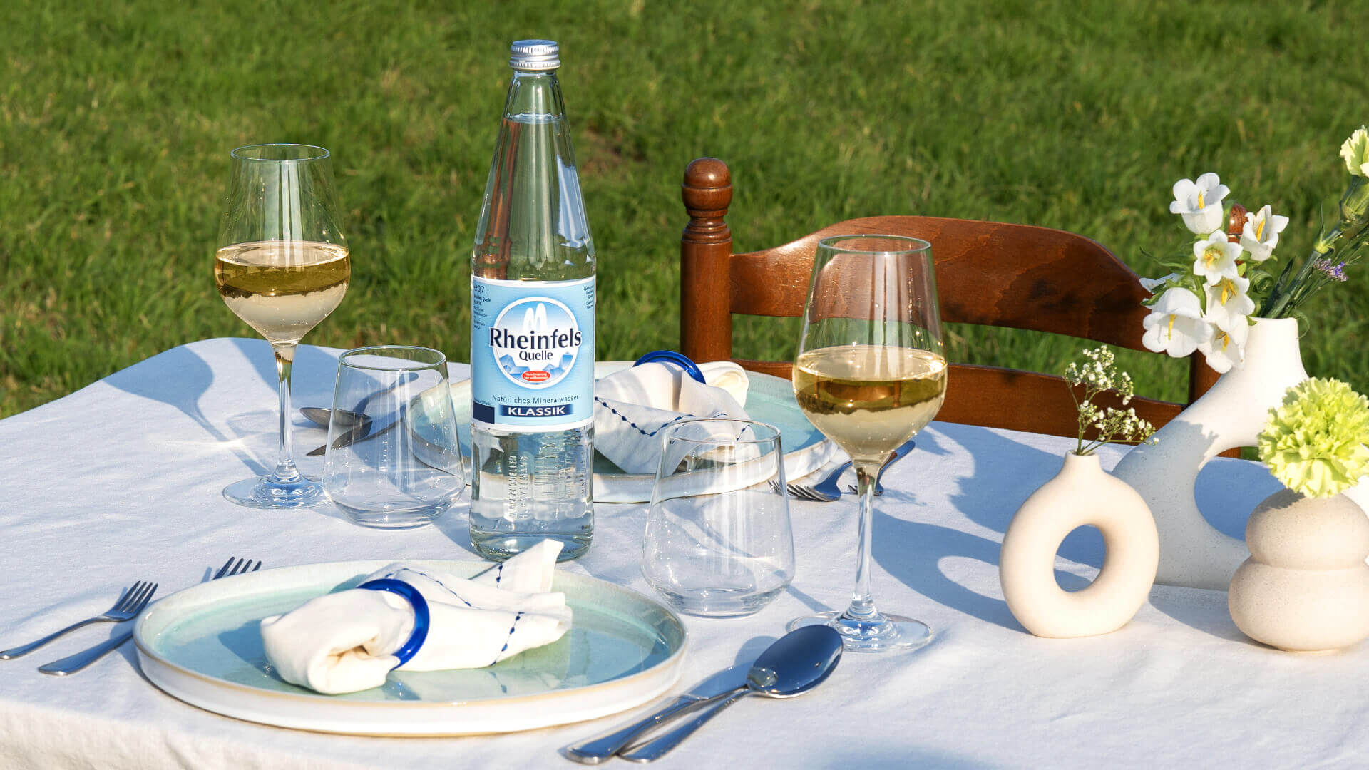 Gedeckter Tisch mit Rheinfels Quelle Klassik und Weißwein