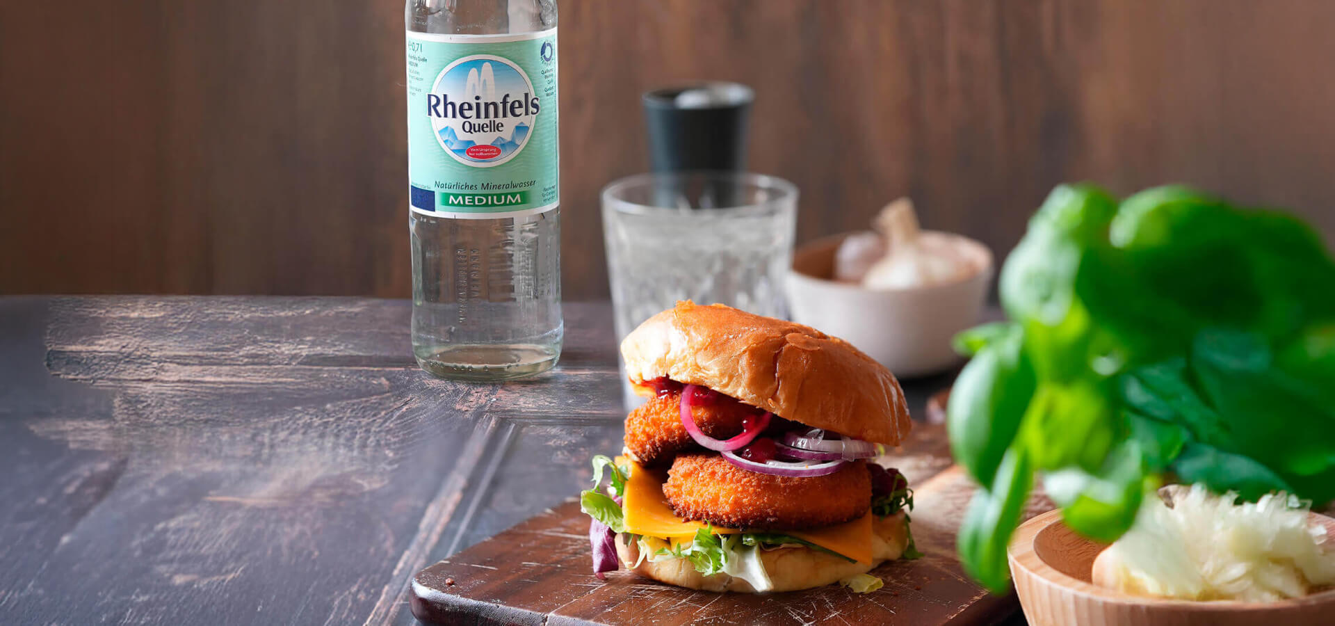 Camembert Burger mit einer Rheinfels Quelle Medium Flasche